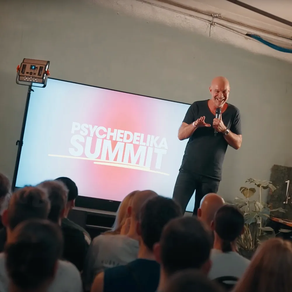 Dr. Stefan Frädrich spricht vor einer Leinwand mit der Aufschrift Psychedelika Summit
