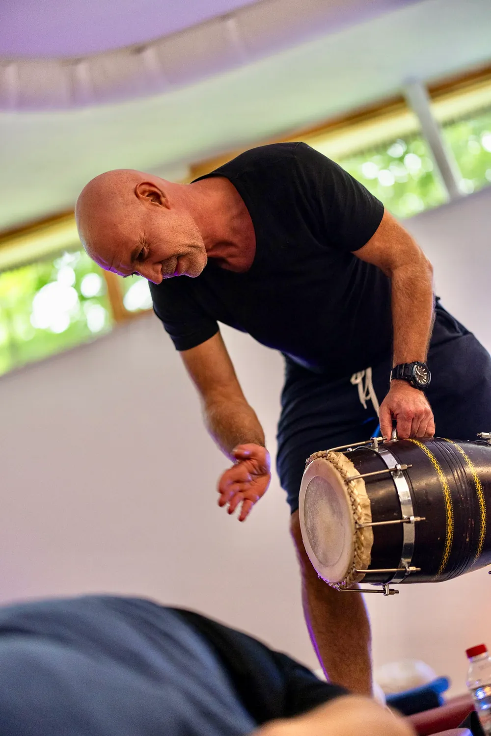 Ein Mann spielt eine Trommel im Seminarraum