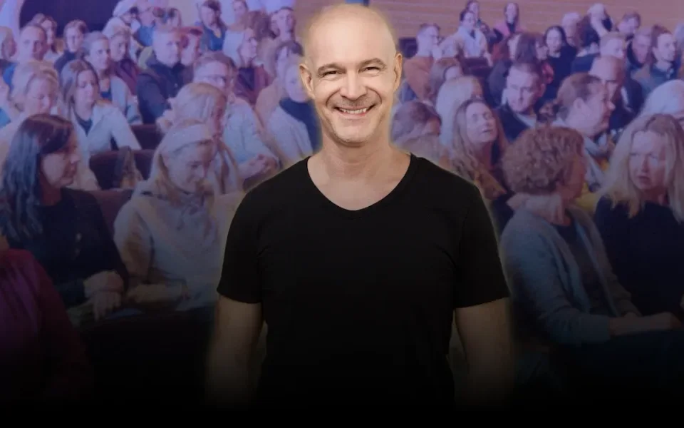 Dr. Stefan Frädrich lächelt vor einem voll besetzten Saal